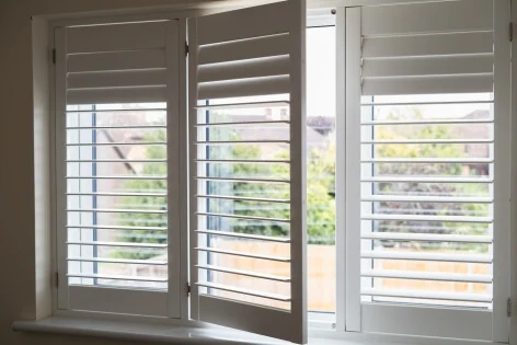 white modern wooden shutters across a window
